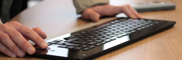 Hände auf einer Tastatur, Teilnehmer schreibt Feedback an die Fotoschule